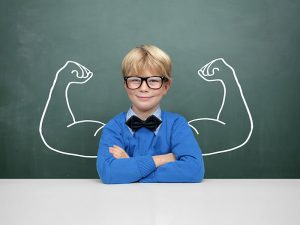 Smiling boy with a background of strong muscle arms on green board
