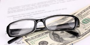 Glasses and 100 dollar notes placed on a document
